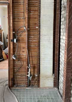 Kitchen walls, stripped to the studs showing knob and tube wiring